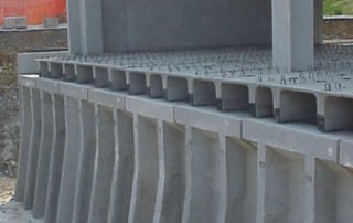 Struttura in cemento prefabbricato con pareti di contenimento e solai in costruzione.