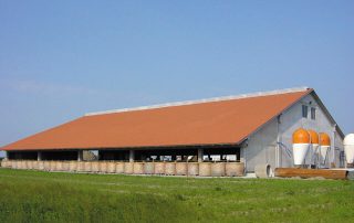 Stalla con tetto a due falde, struttura in cemento e silos.