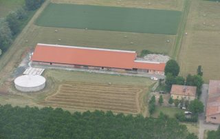 Stalla agricola con annessi, in un paesaggio di campagna, vista dall'alto.