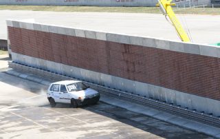 Una macchina durante un crash test impatta contro una barriera fonoassorbente "Paver Sound Integra", dimostrando la resistenza della struttura.