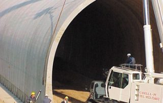 Fase di costruzione di una galleria stradale con elementi prefabbricati in cemento.