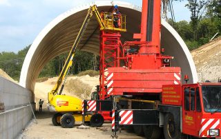 Fase di costruzione di una galleria stradale con elementi prefabbricati in cemento.