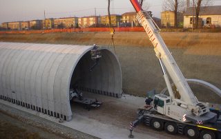 Fase di costruzione di una galleria stradale con elementi prefabbricati in cemento.