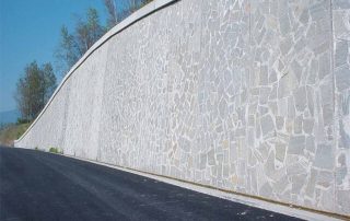 Muro di sostegno prefabbricato in calcestruzzo con rivestimento in pietra naturale.