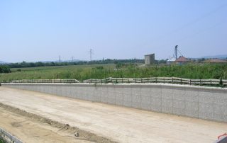 Muro di sostegno prefabbricato in calcestruzzo con finitura effetto pietra.