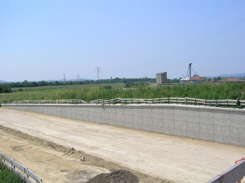 Muro di sostegno prefabbricato in calcestruzzo con finitura effetto pietra.
