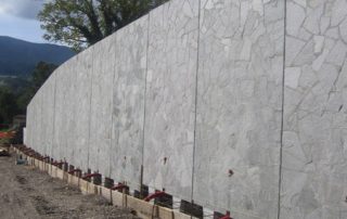 Muro di sostegno prefabbricato con finitura estetica effetto pietra.