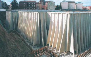 Muri di sostegno prefabbricati in cemento armato installati in un'area di cantiere..