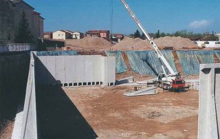 Muri di sostegno prefabbricati in cemento armato in fase di installazione.