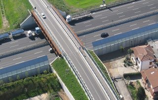 Veduta aerea di un cavalcavia in costruzione sopra un'autostrada a più corsie.