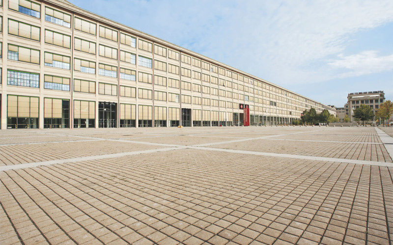 Ampia piazza pavimentata con autobloccanti grigliati davanti al centro espositivo Lingotto Fiere a Torino.