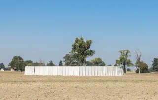 Vasca agricola circolare in cemento posizionata in un campo coltivabile.