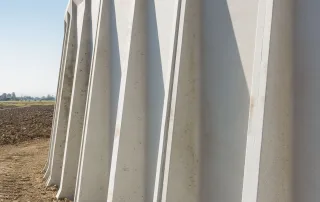 Dettaglio delle pareti esterne di una vasca agricola in cemento, con scanalature verticali.
