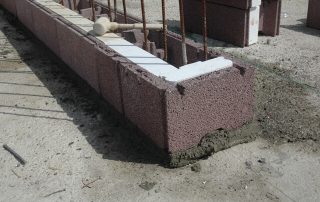 Costruzione di un muro con blocchi BioPLUS®, caratterizzati da una struttura porosa e incastri specifici.