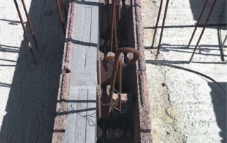 Struttura in costruzione con blocchi BioPLUS®. Barre di armatura in acciaio emergono verticalmente dalla base.