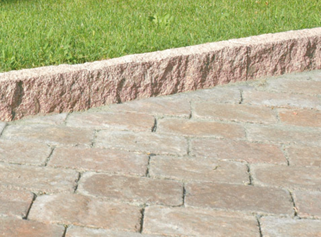 Cordolo in granito rosa con finitura grezza.