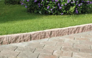 Cordolo in granito rosa con finitura grezza.