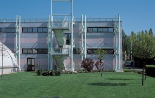 Edificio con facciata rivestita in blocchi di Lecablocco, con scala esterna in metallo.