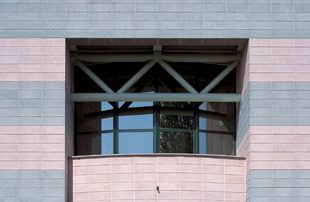 Edificio con facciata a fasce orizzontali realizzate con blocchi di Lecablocco grigi e rosa.