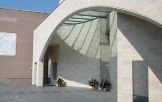 Dettaglio architettonico di una chiesa con struttura ad arco e pareti rivestite in blocchi di Lecablocco.