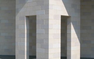 Dettaglio di una struttura architettonica realizzata in Lecablocco chiaro, con elementi verticali che formano un portale.