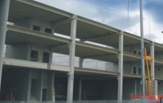 Edificio in costruzione con struttura prefabbricata in cemento e solai multipiano.