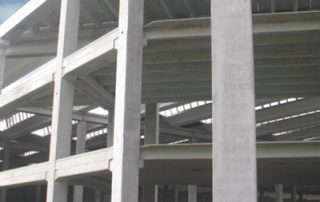 Struttura in costruzione con elementi prefabbricati in cemento e solai a più livelli.