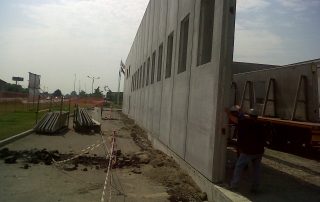 Installazione di un pannello prefabbricato in cemento per un capannone industriale.