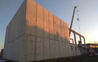 Montaggio di pannelli prefabbricati in calcestruzzo per la costruzione di un edificio industriale.