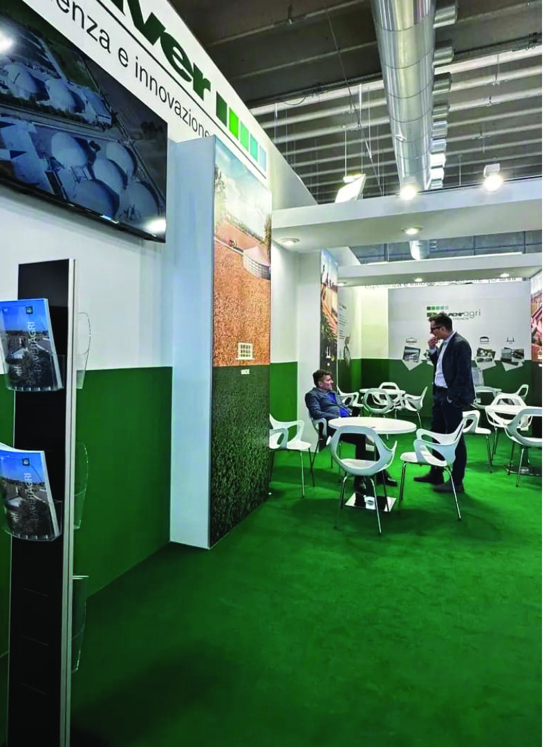 Stand espositivo Paver con area di incontro, pannelli informativi e materiali promozionali.