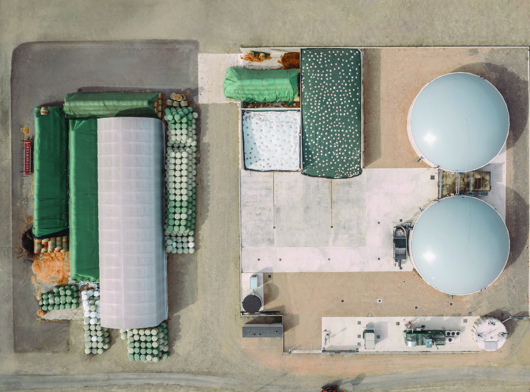 Vista aerea di un impianto di biogas con biodigestori e aree di stoccaggio.