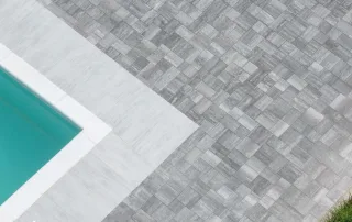 Vista dall'alto del bordo di una piscina con pavimentazione "Anversa" colore Fiammato-Luserna
