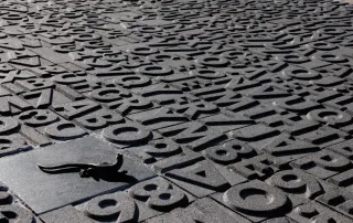 Pavimentazione modello "Poetari", caratterizzata da un design unico con lettere e numeri in rilievo.
