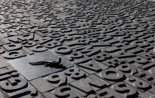 Pavimentazione modello "Poetari", caratterizzata da un design unico con lettere e numeri in rilievo.