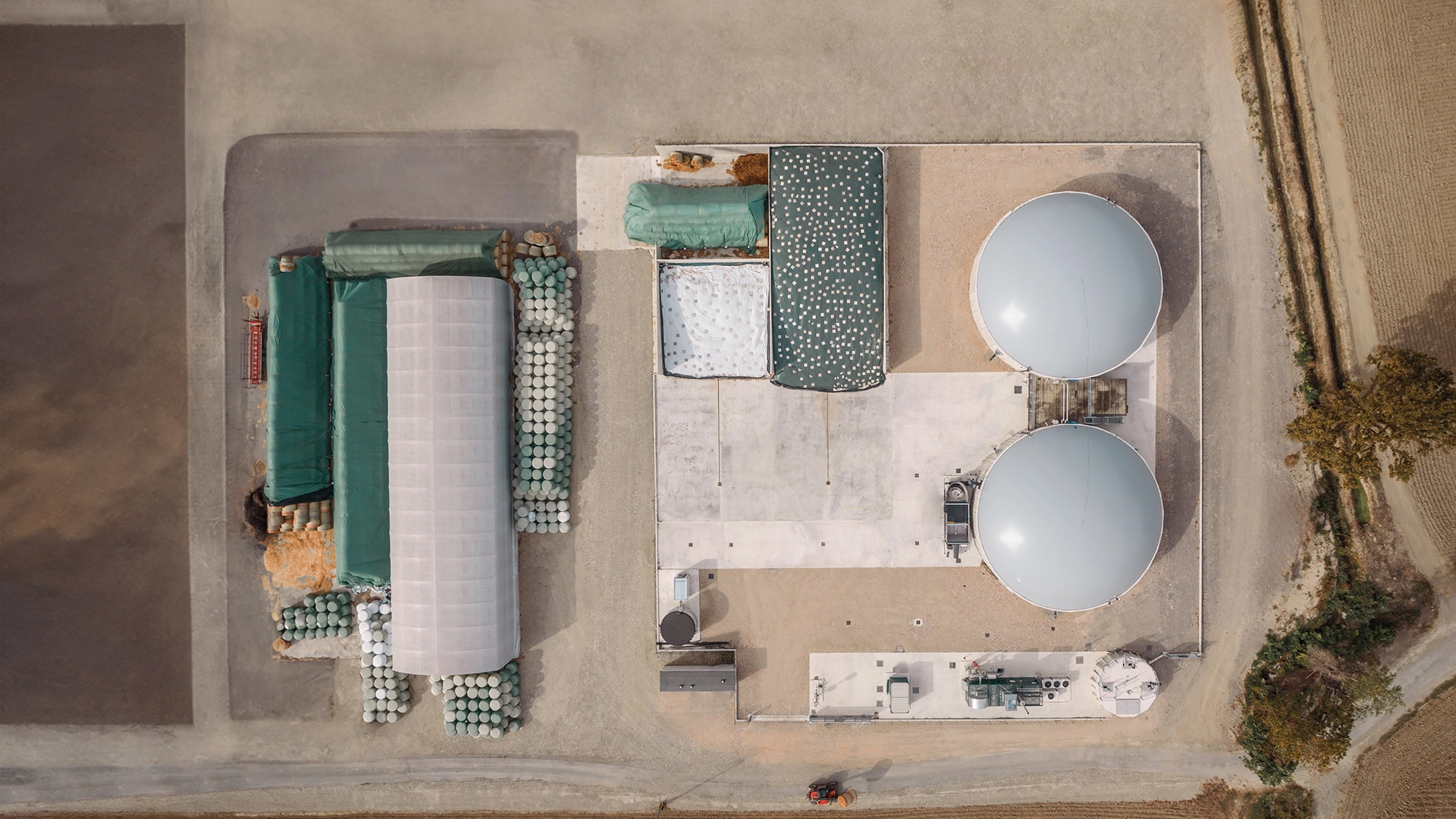 Vista aerea di un impianto di biogas con biodigestori e aree di stoccaggio.