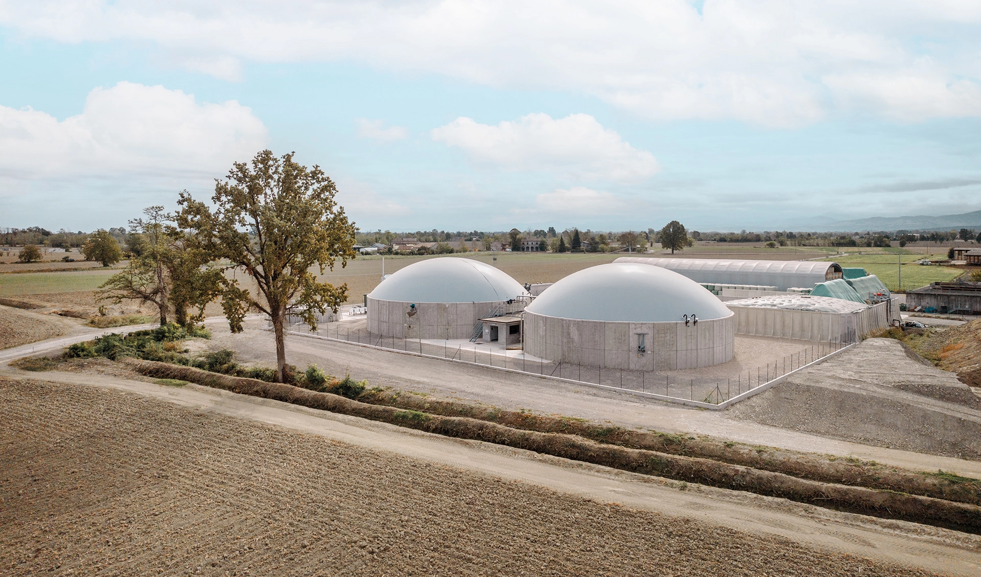 Impianto di biodigestione anaerobica, composto da due grandi serbatoi cilindrici in cemento con copertura a cupola.
