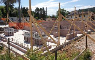 Struttura in costruzione con muri in blocchi BioPLUS e impalcature in legno.
