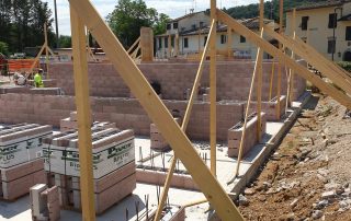 Struttura in costruzione con muri in blocchi BioPLUS e impalcature in legno.