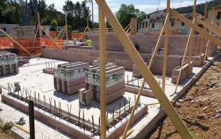 Struttura in costruzione con muri in blocchi BioPLUS e impalcature in legno.