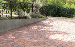 Pavimentazione in cemento con blocchi anticati in tonalità calde.