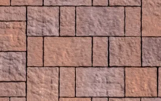 Pavimentazione in cemento con blocchi anticati in tonalità calde.