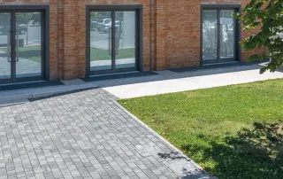 Pavimentazione in cemento con blocchi rettangolari di colore grigio scuro.