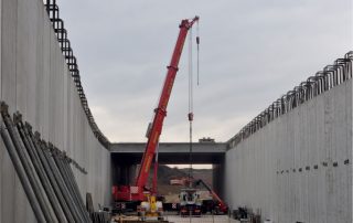 Costruzione di un sottopasso stradale, con pareti prefabbricate in cemento armato e armature metalliche in fase di installazione.