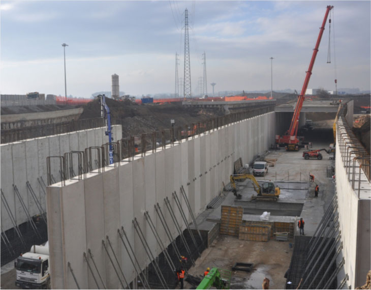 Costruzione di un sottopasso stradale, con pareti prefabbricate in cemento armato e armature metalliche in fase di installazione.