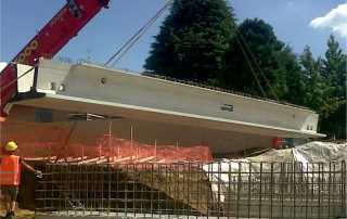 Posizionamento di una trave prefabbricata per la costruzione di un ponte.