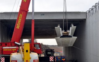 Sollevamento e posizionamento di una trave prefabbricata in cemento armato.