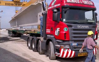 Posizionamento di una trave prefabbricata in cemento armato per la costruzione di un ponte.