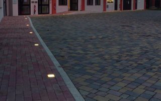Cortile pavimentato con blocchi autobloccanti e illuminazione LED incassata a terra.