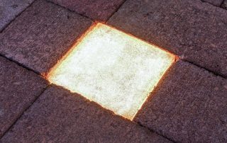 Pavimentazione in pietra con un elemento LED incassato.