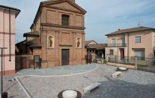 Pavimentazione esterna realizzata con autobloccanti di diverse tonalità di grigio e rosa.
